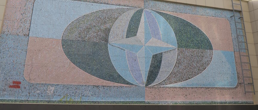 A mural is split into quadrants, and features a four point star on top of an oval globe, in Chita.