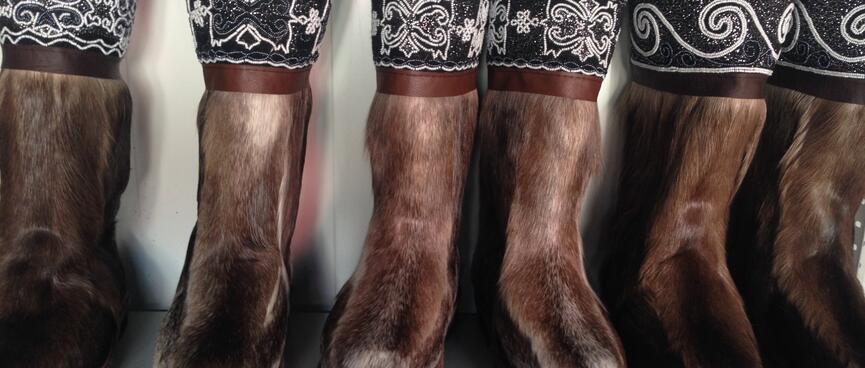 A shelf of brown fur boots look like horse legs.