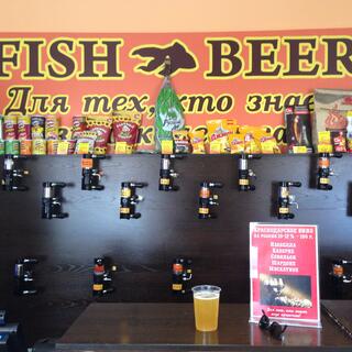Beer taps cover a wall under a large sign stating FISH BEER, in Chita.