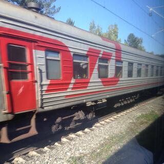 A large red Russian Railways logo brightens up a grey passenger carriage.