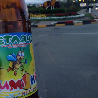 My drink label features a drawing of a bee, and in the background there is a giant bee model.