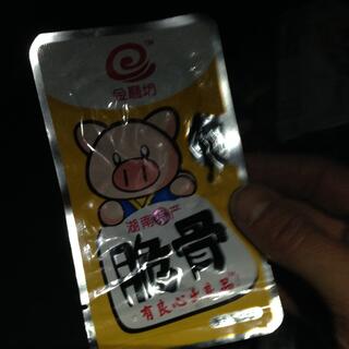 A metallic packet features bold chinese writing and the cartoon face of a pig.