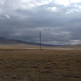 A lonely pole in a barren moody landscape.