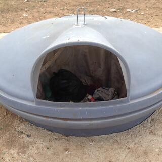 A large, covered saucer-shaped rubbish bin.