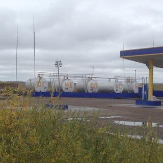 A row of storage tanks containing different types of gasoline.