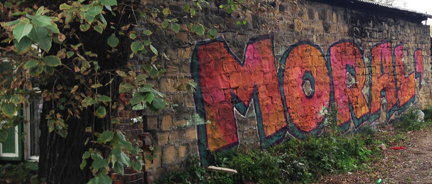 The tag MORAL adorns a wall in block lettering.