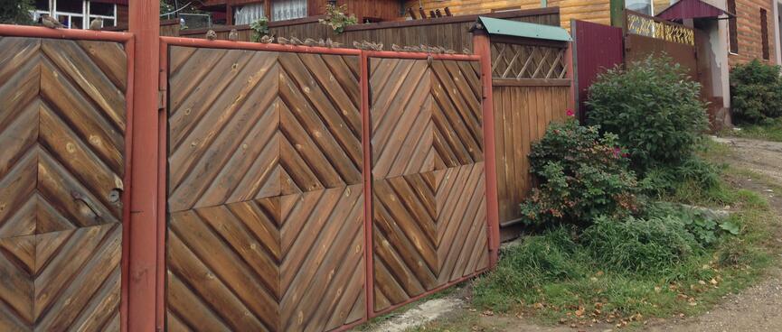 A fence is decorated with diagonal wooden slats.