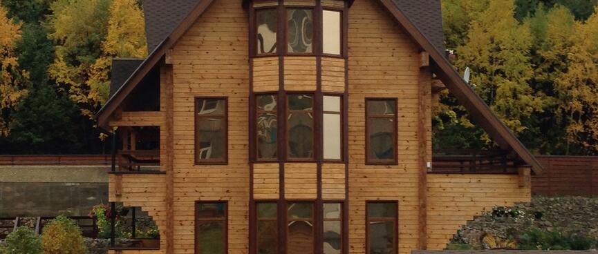 Thirteen windows on the frontage of a three story wooden house.