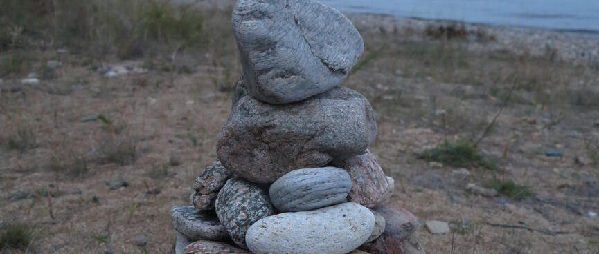 Large rocks are stacked up on the beach.