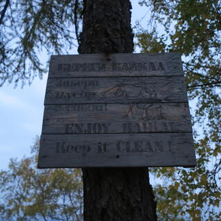 A wooden sign reads: ENJOY BAIKAL. Keep it CLEAN!