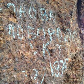 Chalk Cyrillic on the rock wall.