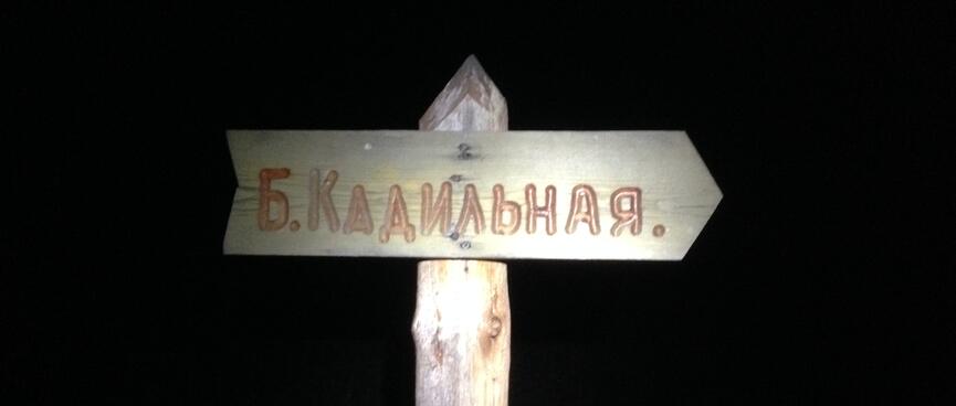 A wooden sign is in Cyrillic only.