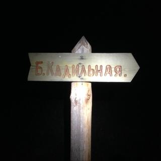 A wooden sign is in Cyrillic only.
